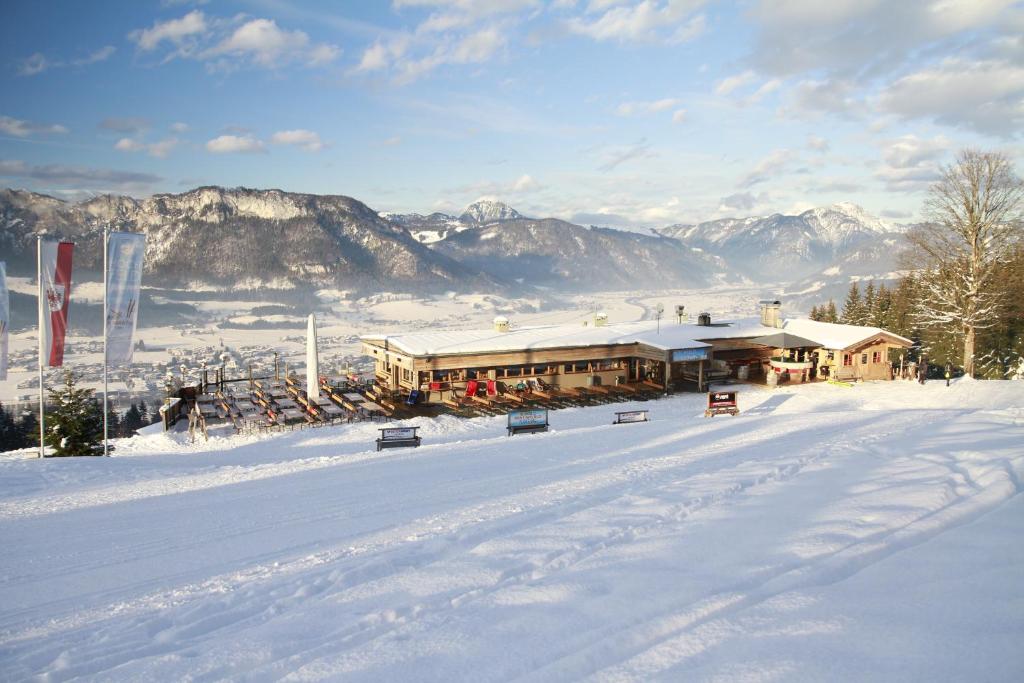 domek narciarski na śniegu z górami w tle w obiekcie Hochfeldalm w mieście Sankt Johann in Tirol