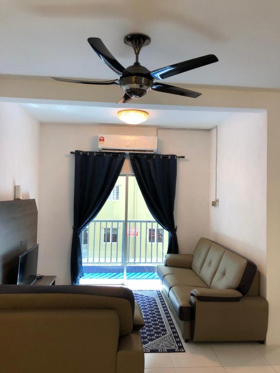 a living room with a couch and a ceiling fan at CASA IDAMAN - Islamic Homez in Malacca