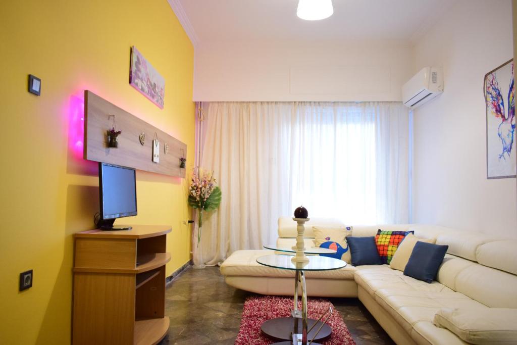 a living room with a white couch and a tv at Mary's Apt 2bedrooms in Allou Fun Park West Athens by MK in Piraeus