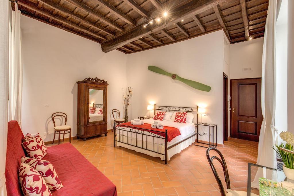1 dormitorio con cama, sofá y espejo en Piccolo Trevi Suites, en Roma