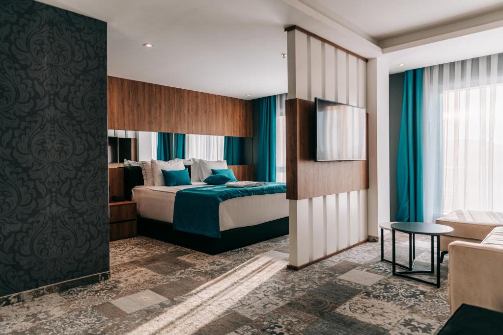 una camera d'albergo con letto e divano di Palace Hotel & SPA a Kosovska Mitrovica