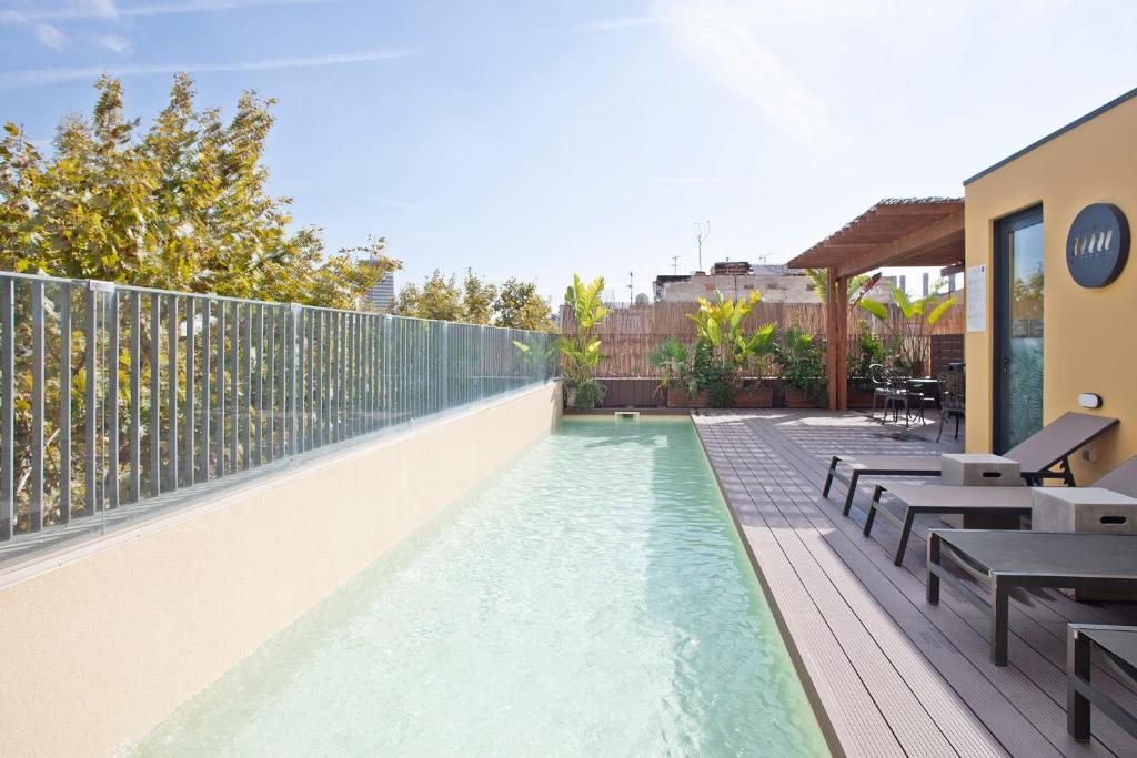 una piscina su un balcone con tavoli e panche di Niu Barcelona Hotel a Barcellona