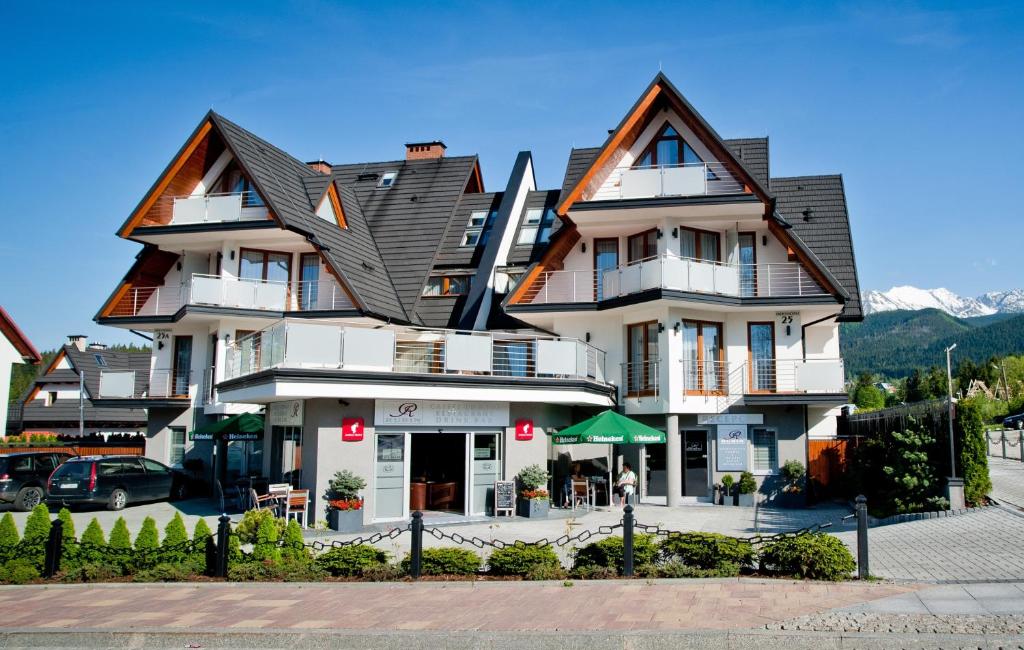 een groot wit gebouw met een dak bij Apartamenty Rubin in Zakopane