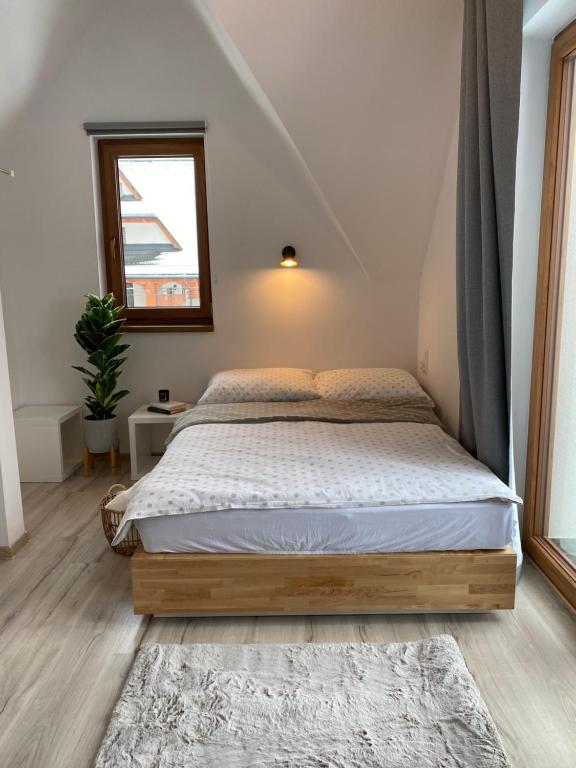 a bedroom with a bed and a window at Domek MAYA Górska Chata - 200m od stoków Kotelnica i Termy Bania in Białka Tatrzanska