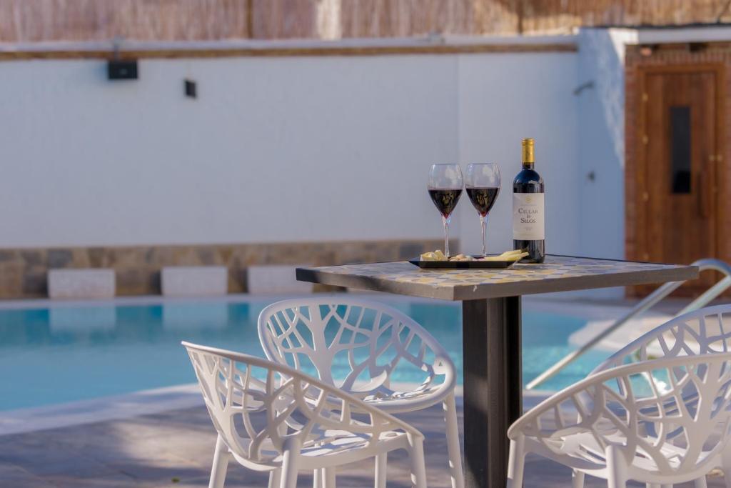 a table with two glasses of wine and two chairs at Hotel Boutique Sibarys - Adults Recommended in Nerja