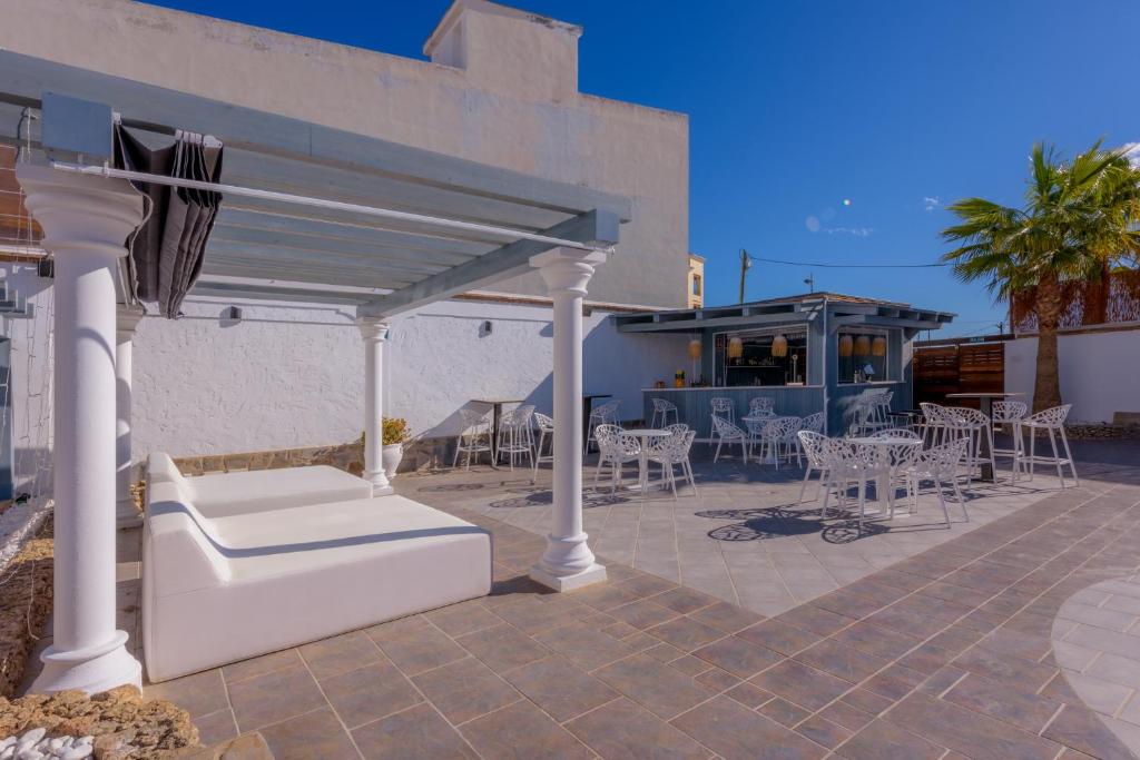 a patio with a white canopy and tables and chairs at Hotel Boutique Sibarys - Adults Recommended in Nerja