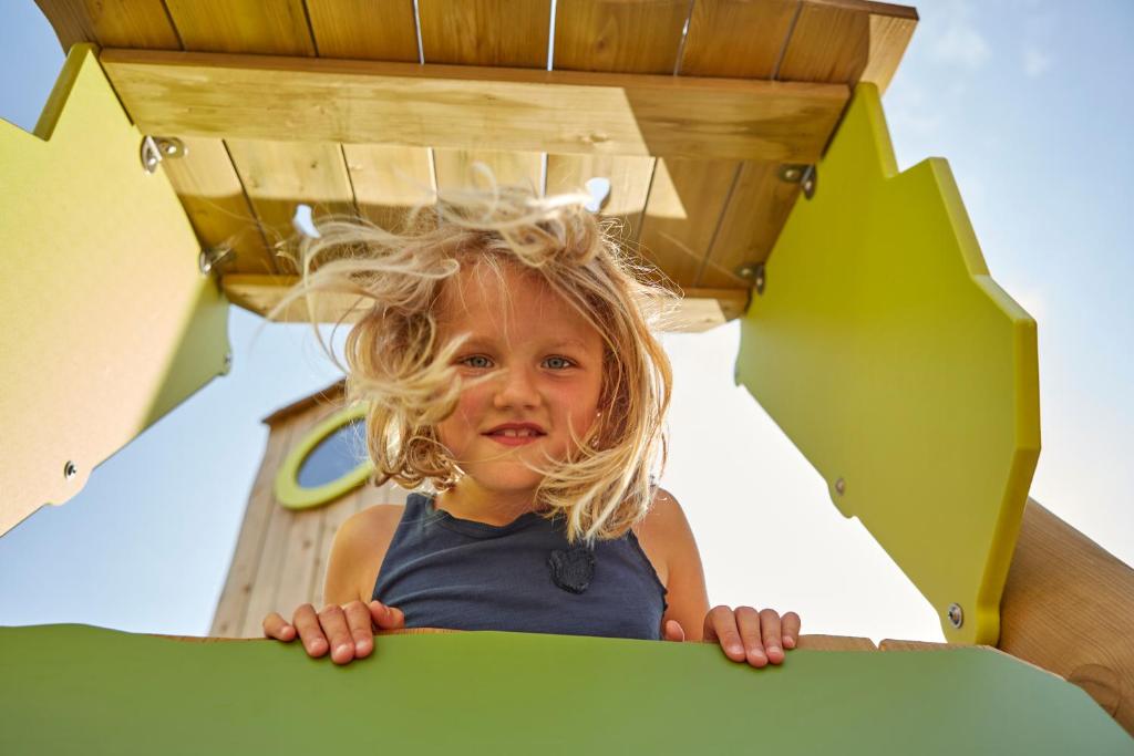 トラッセンハイデにあるTUI SUNEO Kinderresort Usedomの乗り物の上に立つ少女