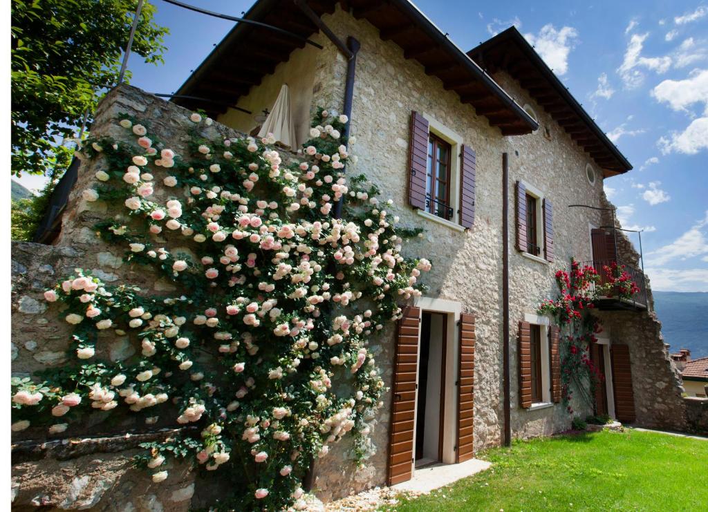 a building with roses on the side of it at Residence Fondo La Campagnola in Gargnano