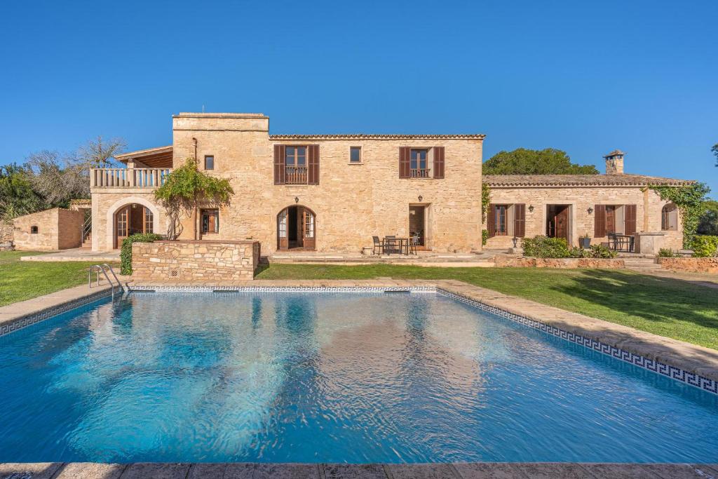 una grande piscina di fronte a una casa di Es turo d Eivissa a Ses Salines