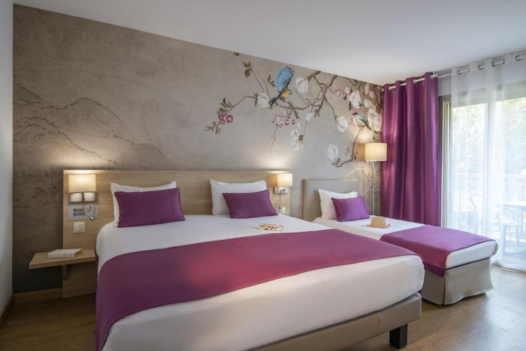 a bedroom with a large bed with purple pillows at Hotel Chambord in Menton