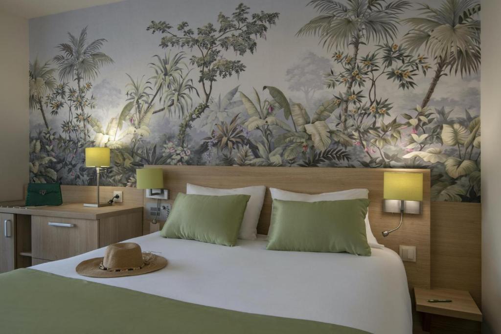 a bedroom with a bed with a hat on it at Hotel Chambord in Menton