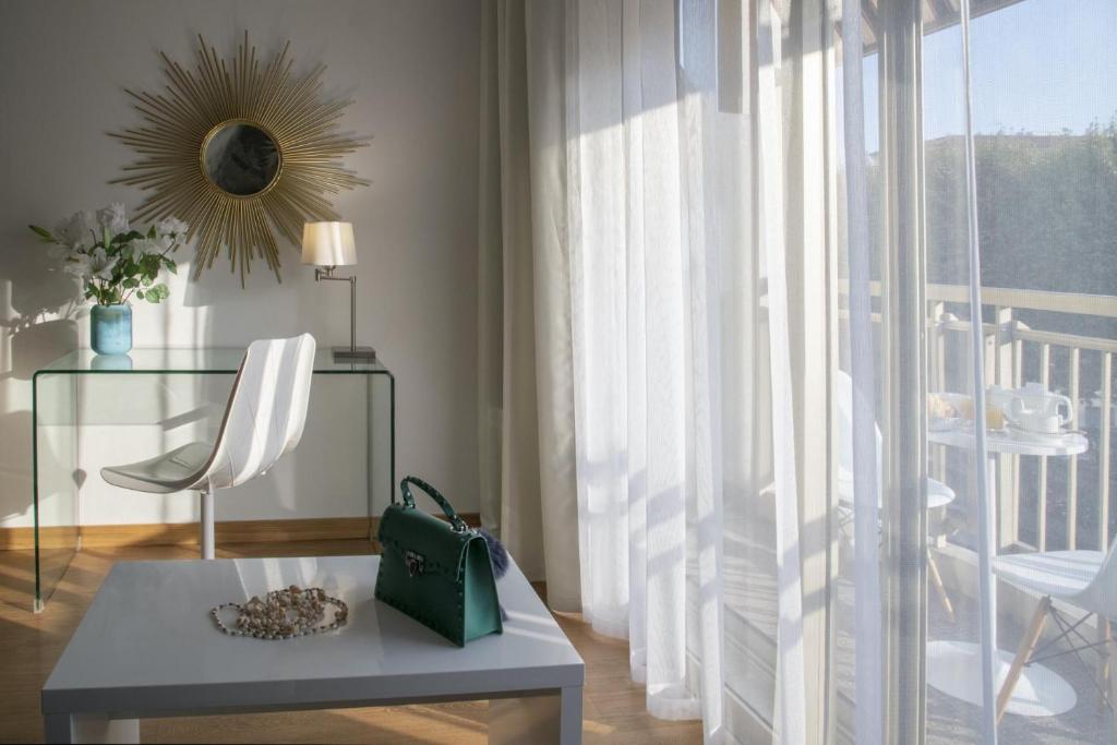 a living room with a chair and a table and a window at Hotel Chambord in Menton