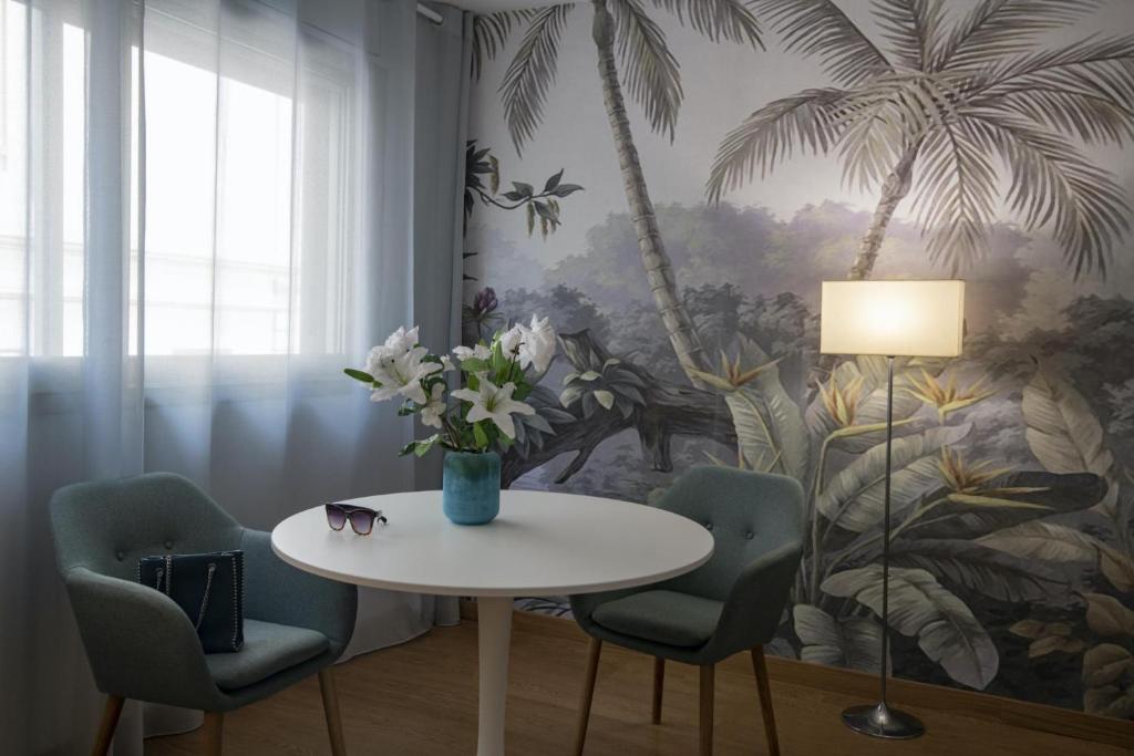 a table and chairs with a vase of flowers on it at Hotel Chambord in Menton