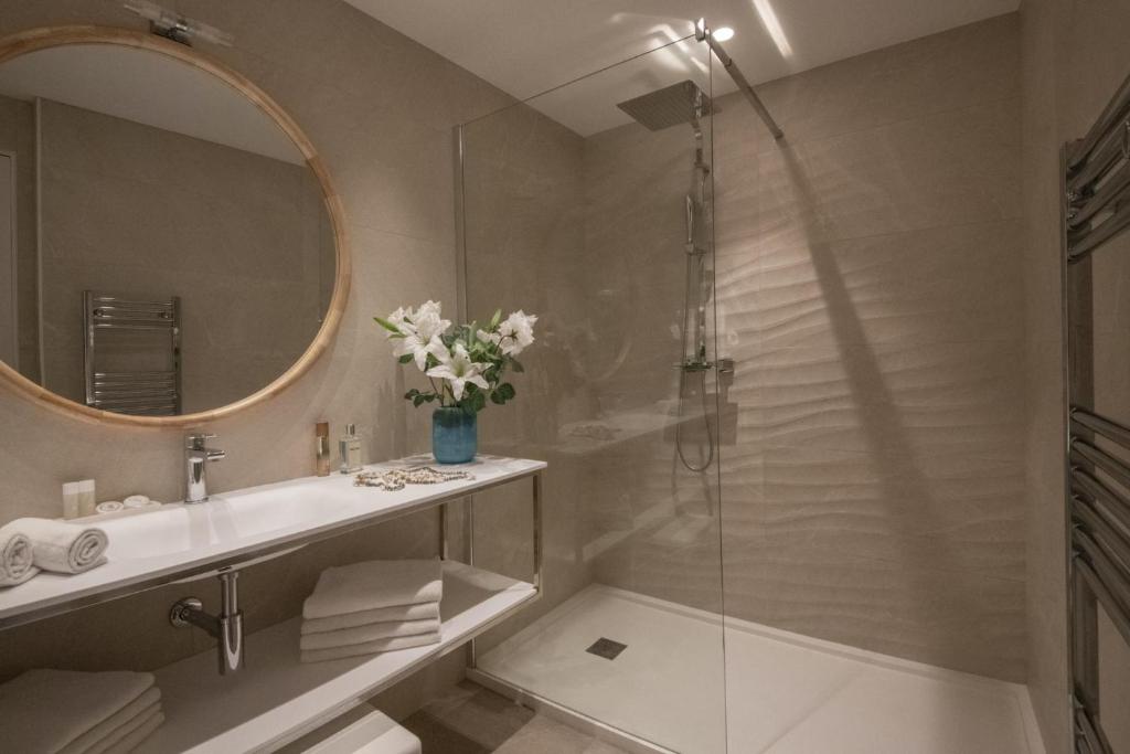 a bathroom with a shower and a sink and a mirror at Hotel Chambord in Menton