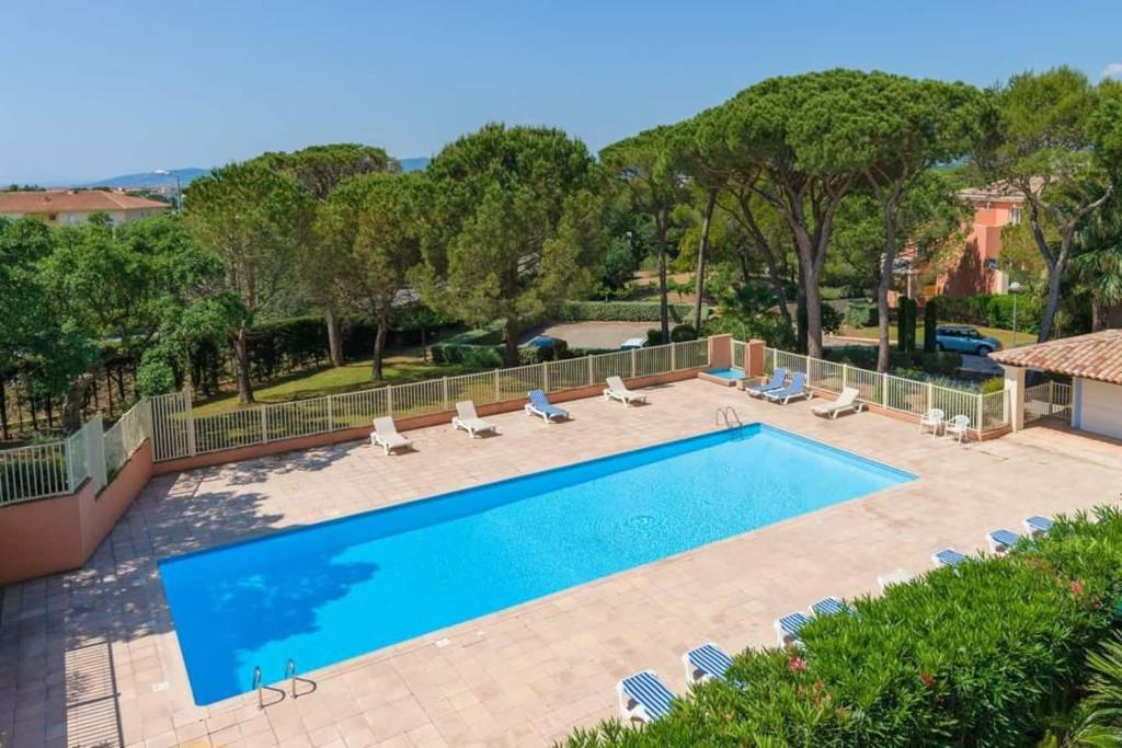 una gran piscina con tumbonas y una piscina en Appartement St Raphael neuf - Résidence privée avec Piscine & Tennis en Saint-Raphaël