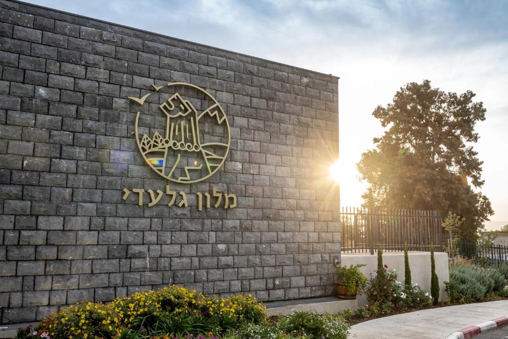 a sign on the side of a brick building at Giladi Hotel in Kefar Gil‘adi