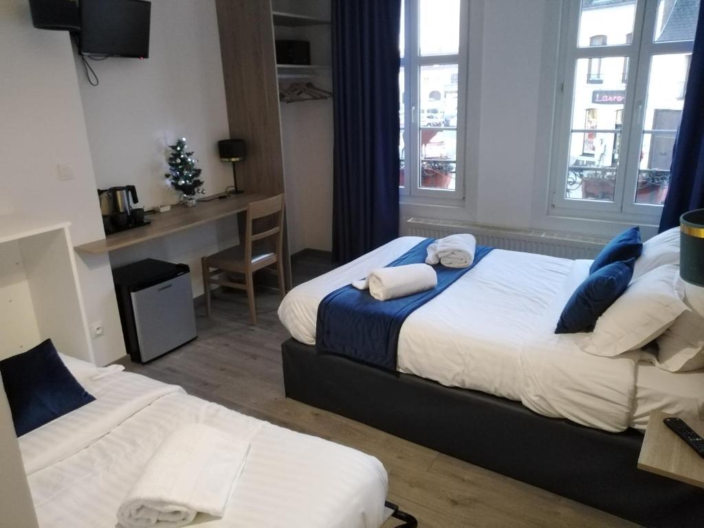 a hotel room with two beds and a desk at Les Remparts in Montreuil-sur-Mer
