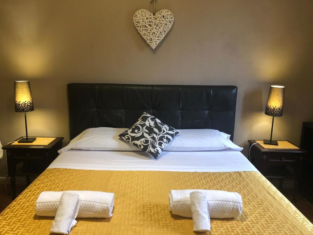a bedroom with a large bed with two towels on it at Hotel Casale dei Massimi in Rome