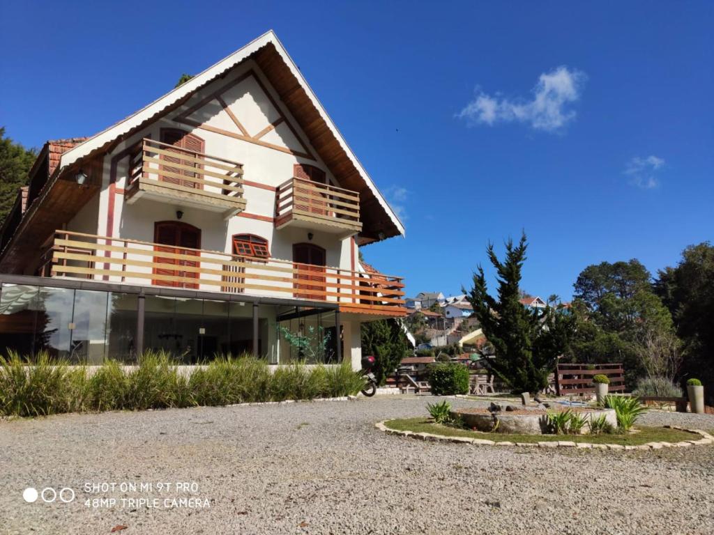 a house with a balcony on the side of it at Pousada Château dos Fontes in Campos do Jordão