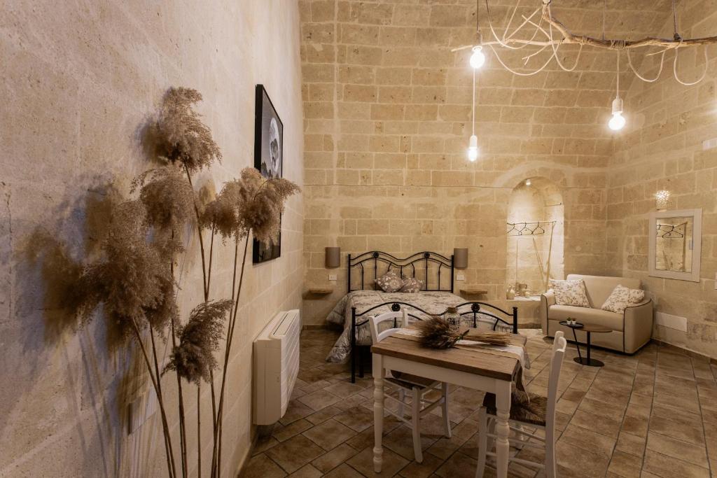 Zimmer mit einem Bett, einem Tisch und einem Sofa in der Unterkunft Antichi Orizzonti in Matera