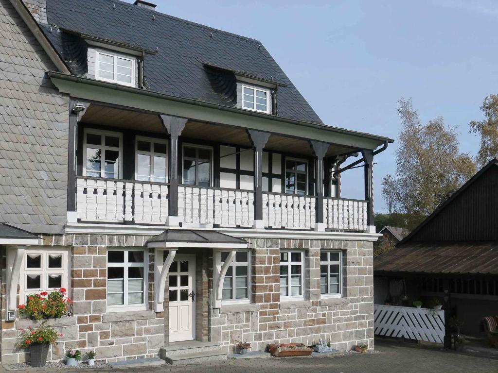 a large brick house with a white balcony at Ferienwohnung Wennetal in Schmallenberg
