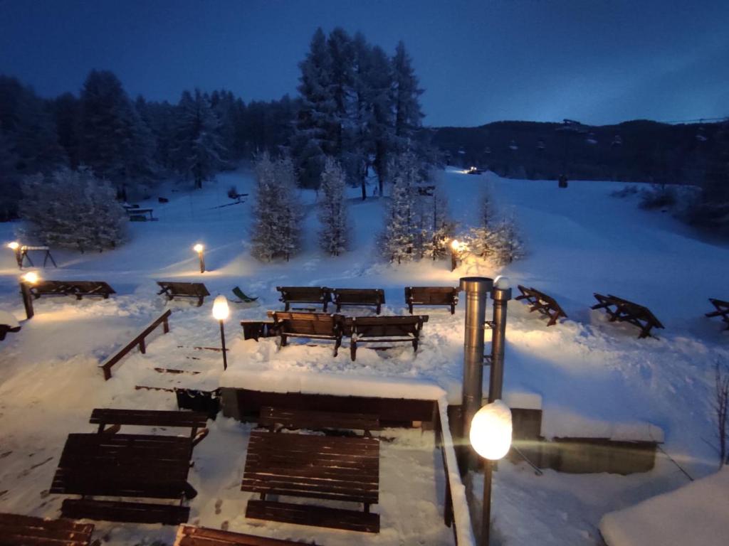 サウゼ・ドゥルクスにあるRestaurant Hotel Chalet Del Soleの夜の雪の中のピクニックテーブル