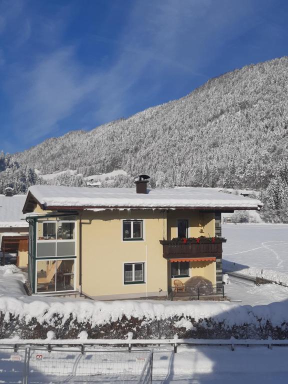 a house in the snow with a mountain in the background at Haus Laimbauer in Kirchdorf in Tirol