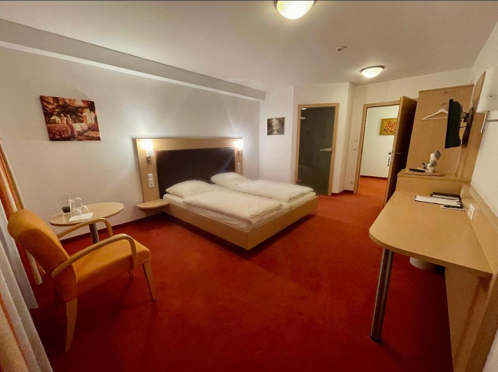 LILTON Hotel Stuttgart-Zuffenhausen في شتوتغارت: غرفة نوم بسرير وطاولة ومكتب