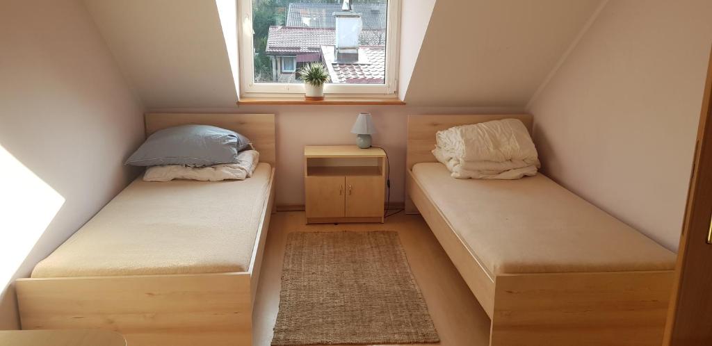 a small room with two beds and a window at Domek w Poddąbiu blisko plaży i lasu in Poddąbie