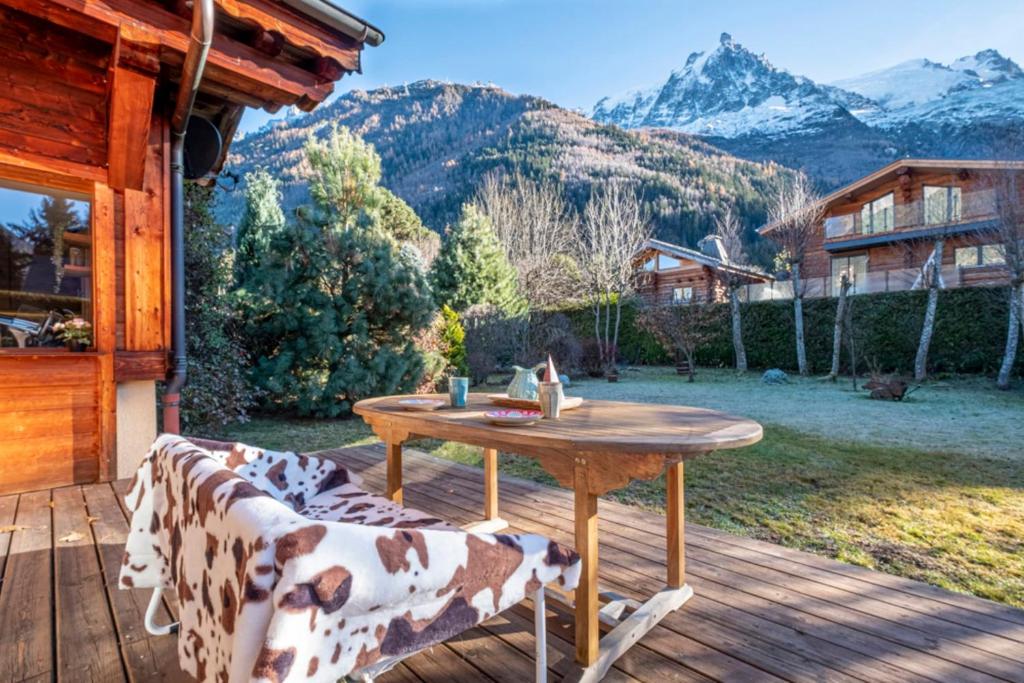 un tavolo in legno su una terrazza con vista sulle montagne di Nice And Spacious Apt In Chamonix Mont Blanc a Chamonix-Mont-Blanc