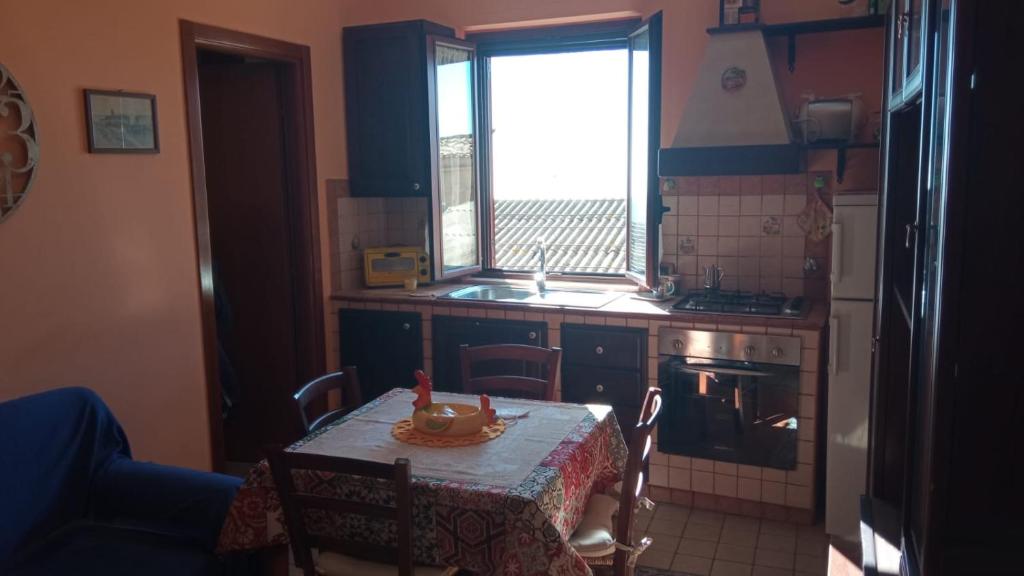 una piccola cucina con tavolo e finestra di Scorcio Di Mare a Agrigento