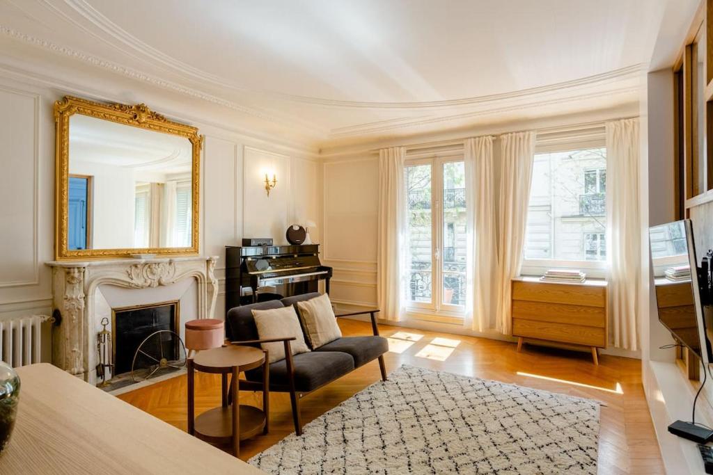 a living room with a couch and a mirror at Bel appartement dans le 9ème in Paris