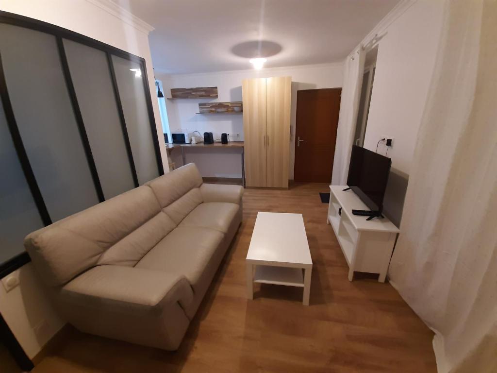 - un salon avec un canapé et une table dans l'établissement Appartement 2 pièces, proche RER, Bus et chateau, à Rambouillet