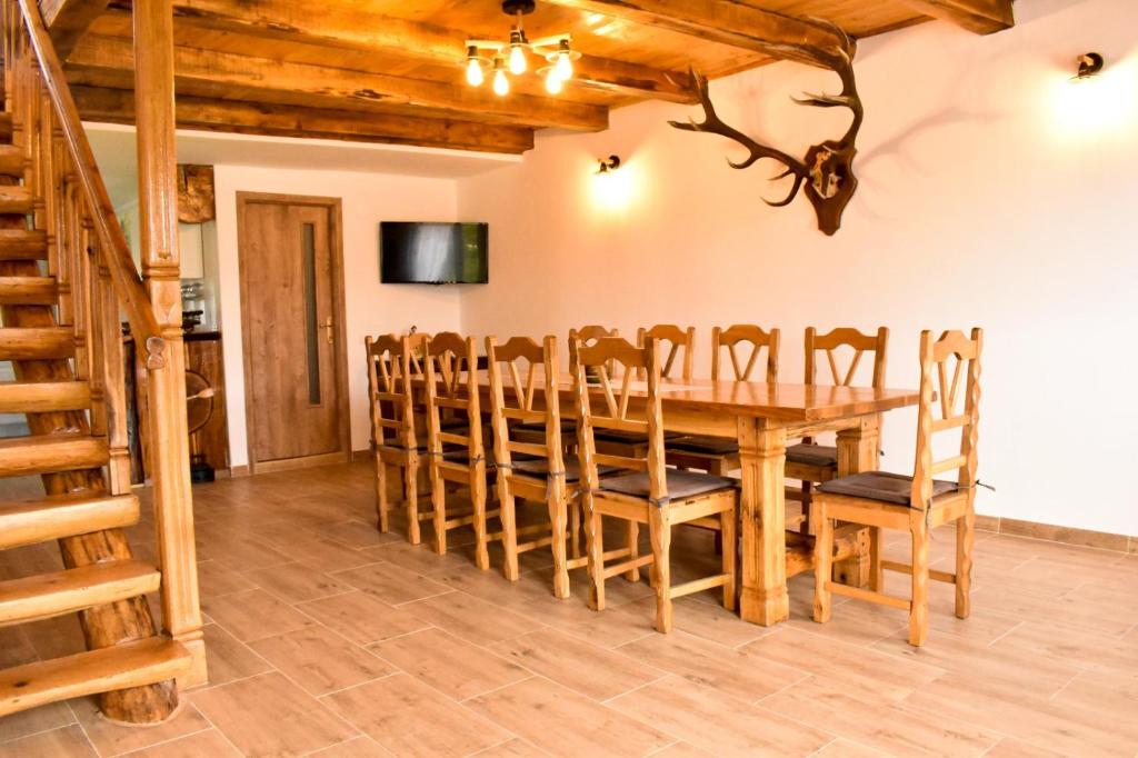 Un comedor con mesa y sillas de madera. en Casa de sub Horă, en Zărneşti