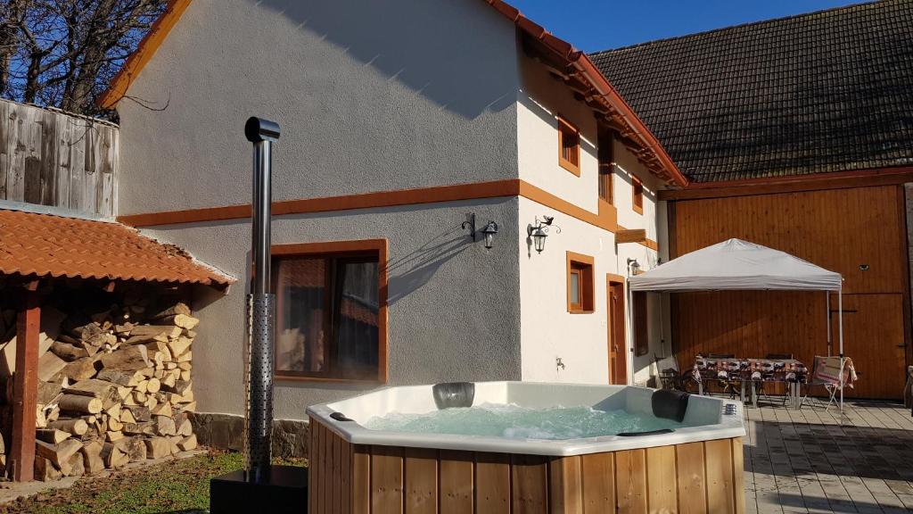 a hot tub in a yard next to a building at Otto's Guesthouse in Prejmer