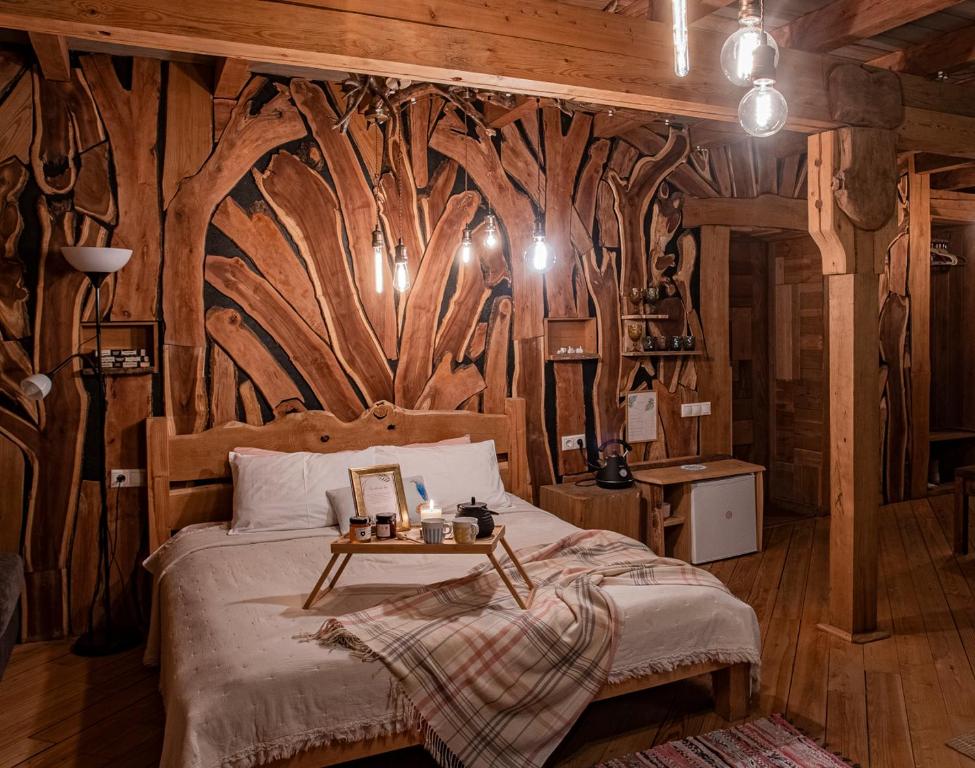 a bedroom with a bed with a wooden wall at Guest House Old Boys in Krasnaya Polyana