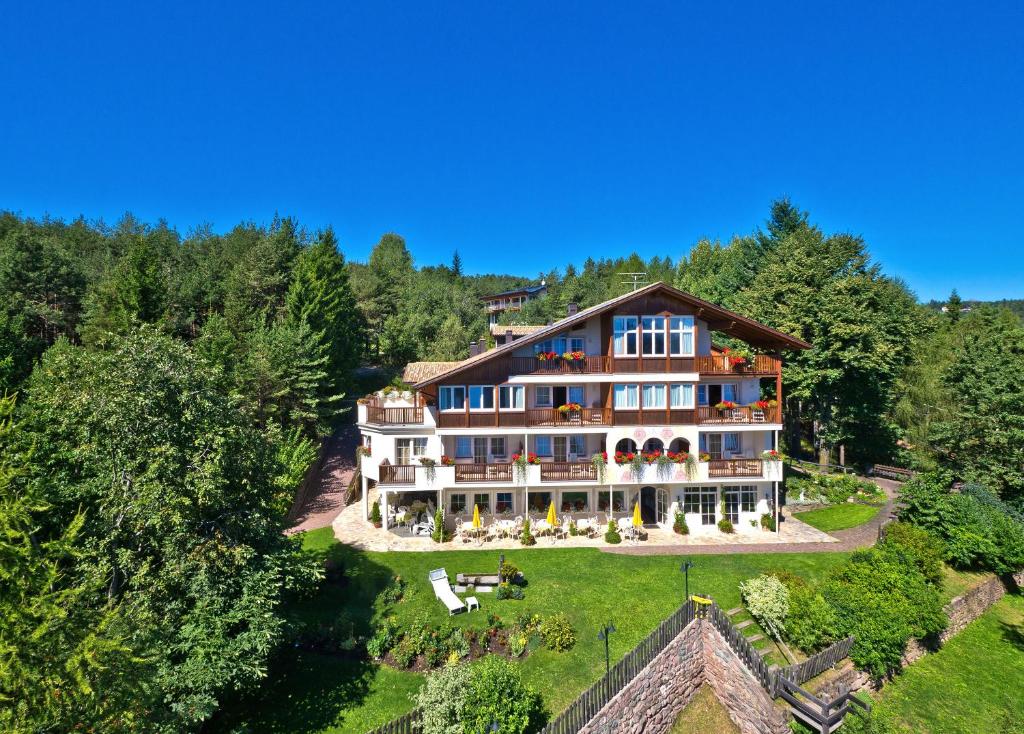 una vista aérea de una gran casa en una colina en Hotel König Laurin, en San Genesio Atesino