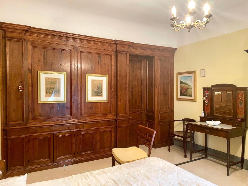 sypialnia z drewnianymi szafkami, stołem i łóżkiem w obiekcie CESARE'S HOME w Katanii