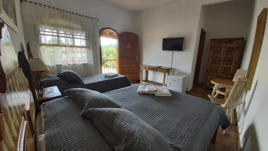 a living room with a bed and a couch at Pousada da josi - Tiradentes in Tiradentes