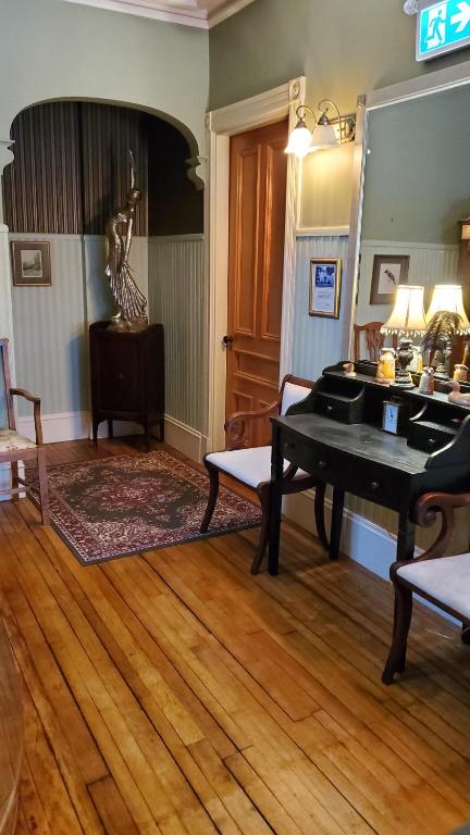 a living room with a piano and a table at The Lark & Loon Inn in Annapolis Royal