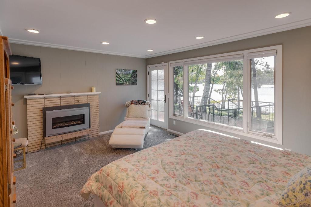 sypialnia z łóżkiem, kominkiem i krzesłem w obiekcie Whitefish Lake Home with Heated Indoor Pool w mieście Manhattan Beach