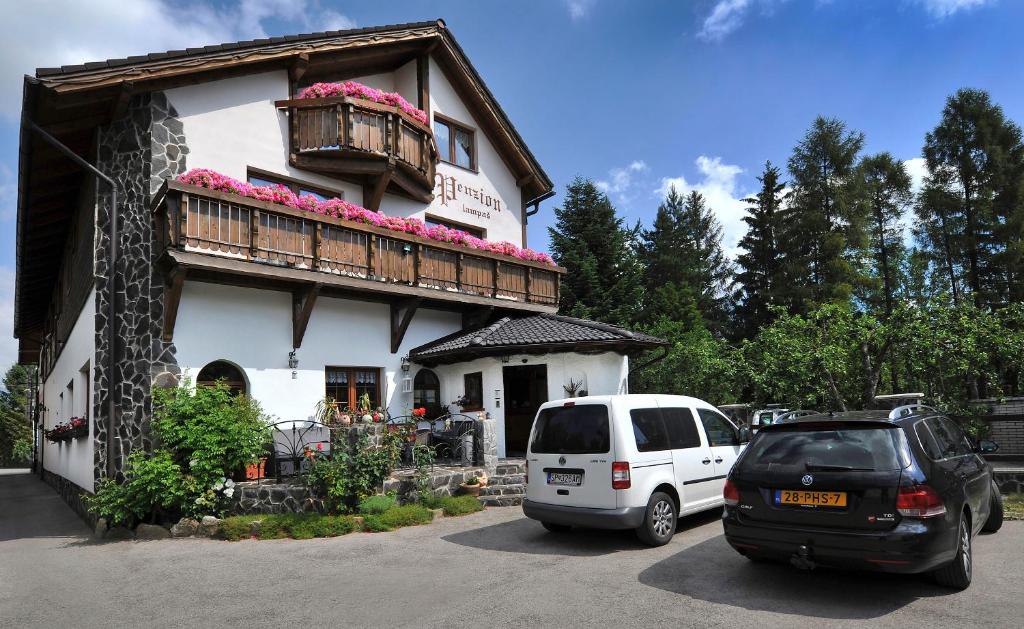 two cars parked in front of a building at Penzión Lampáš in Poprad