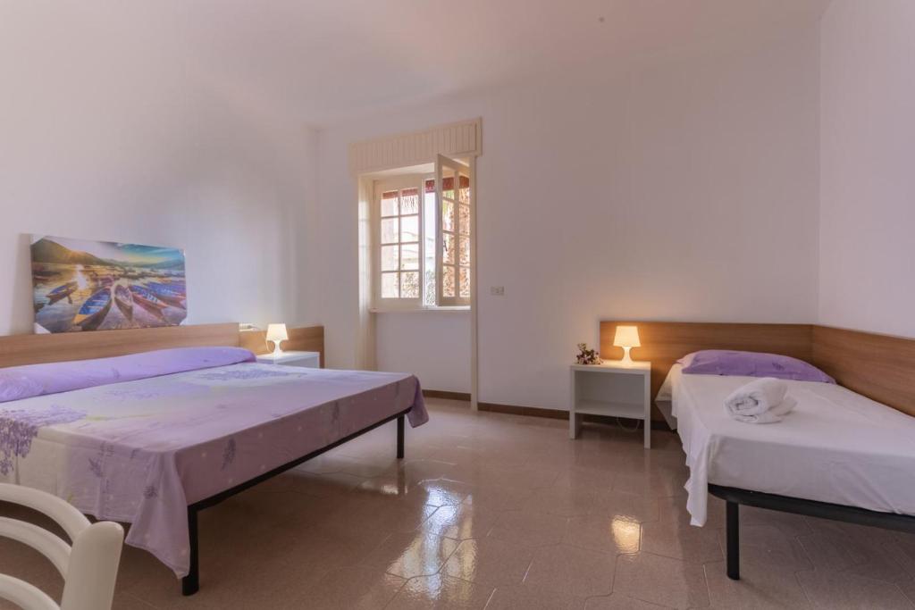 duży pokój z 2 łóżkami i oknem w obiekcie VILLA ISCHIA w mieście Torre Suda