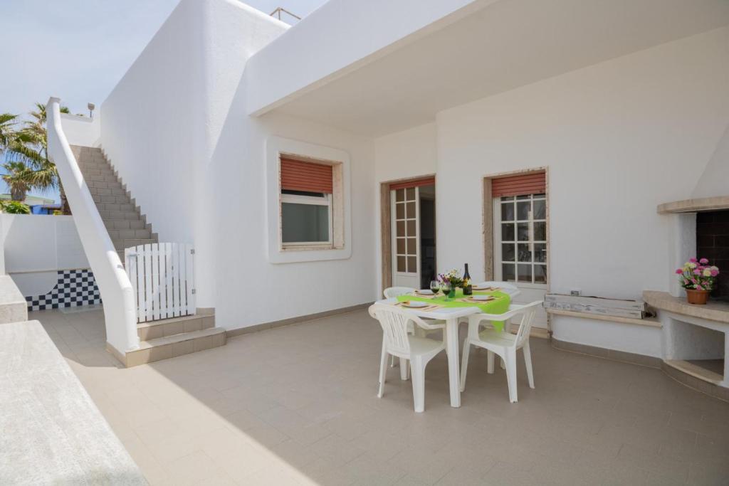 biała jadalnia ze stołem i krzesłami w obiekcie VILLA ISCHIA w mieście Torre Suda