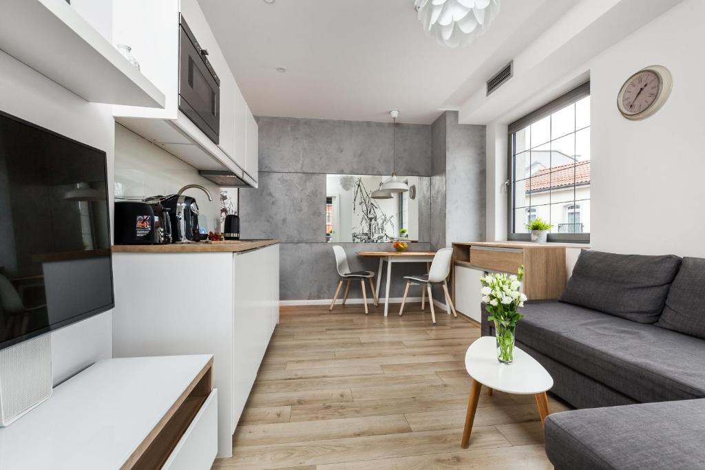 a living room and kitchen with a couch and a table at Happy Stay Tartaczna Residence II in Gdańsk