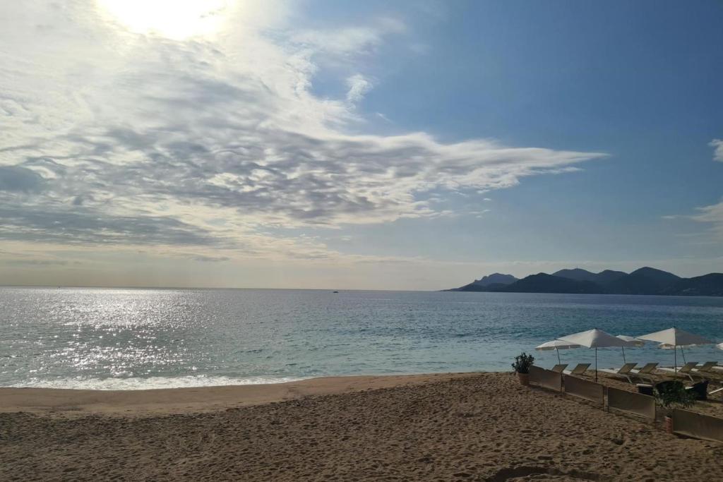 une plage de sable avec des parasols et l'océan dans l'établissement Bel Apt Near Croisette Beach Cannes, à Cannes