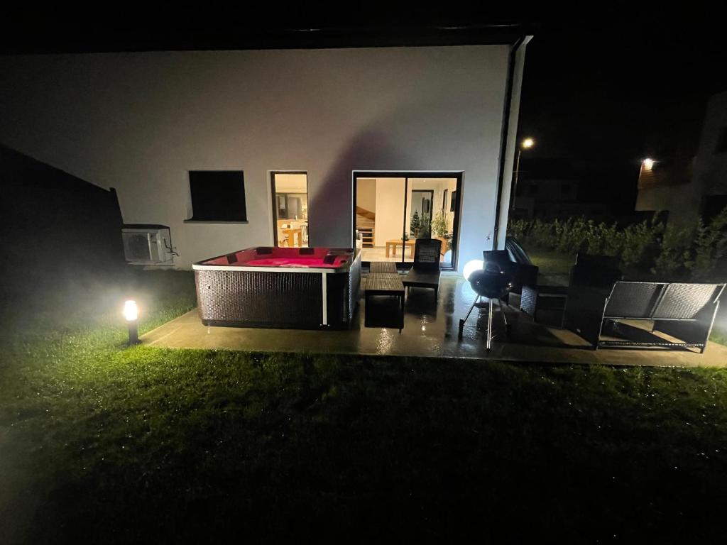 a backyard at night with a hot tub in the yard at Le Paradis du petit Rupembert in Wimille