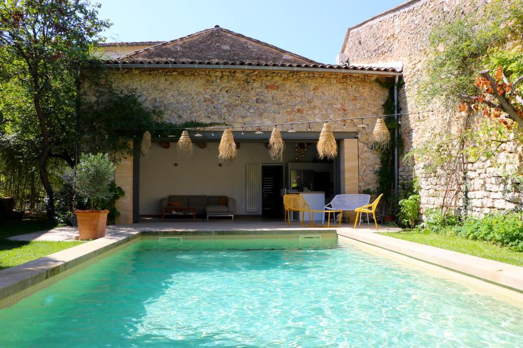 a swimming pool in front of a house at Les Nuits Pétillantes in Cournonterral