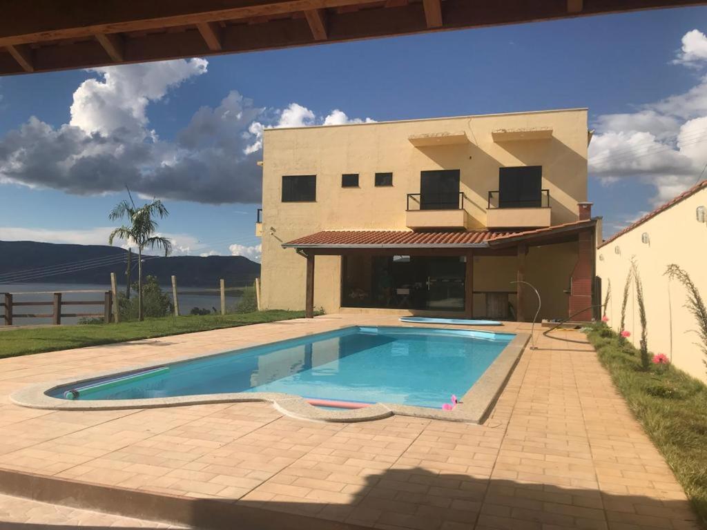 a swimming pool in front of a house at Rancho Chega Mais 2 in Carmo do Rio Claro