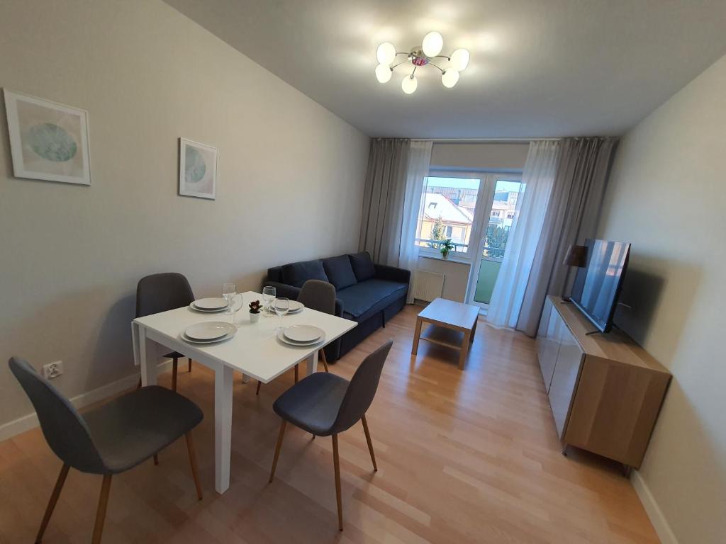 a living room with a white table and chairs at Apartament APART Zagony in Wrocław
